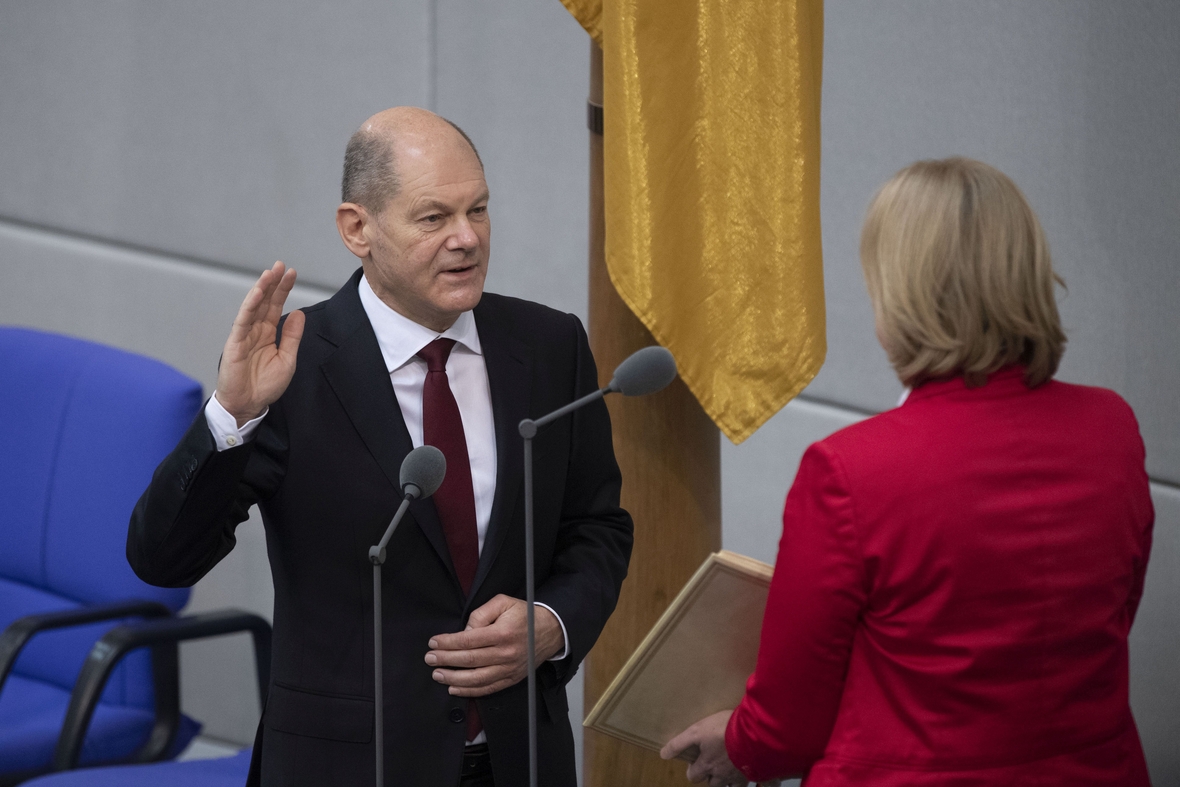 Bundeskanzler Olaf Scholz spricht vor der Bundestagspräsidentin den Amtseid. Er hebt die linke Hand zum Schwur.