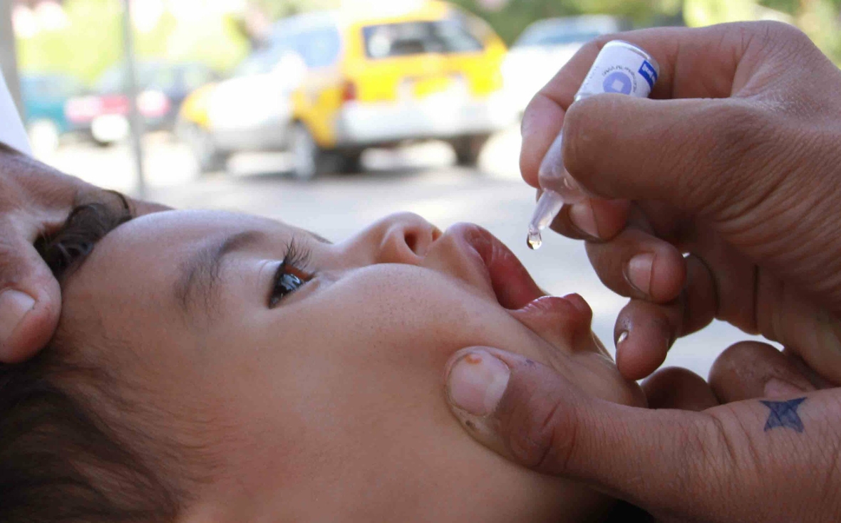 Mit einer Schluckimpfung wird ein Kind gegen Kinderlähmung geimpft. Die WHO unterstützt diese Aktionen weltweit wie hier in Afghanistan.