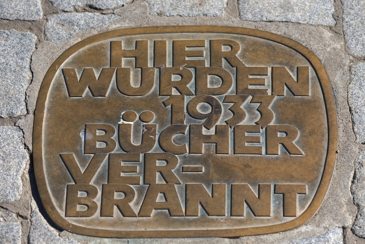 Gedenkplatte zur Erinnerung an die Bücherverbrennung 1933 auf dem Schlossplatz in Erlangen. Auf der Platte steht: Hier wurden 1933 Bücher verbrannt.