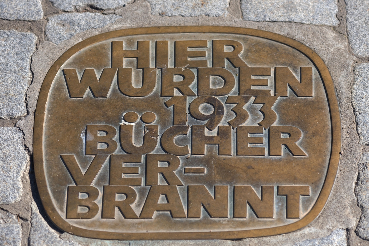 Gedenkplatte zur Erinnerung an die Bücherverbrennung 1933 auf dem Schlossplatz in Erlangen. Auf der Platte steht: Hier wurden 1933 Bücher verbrannt.