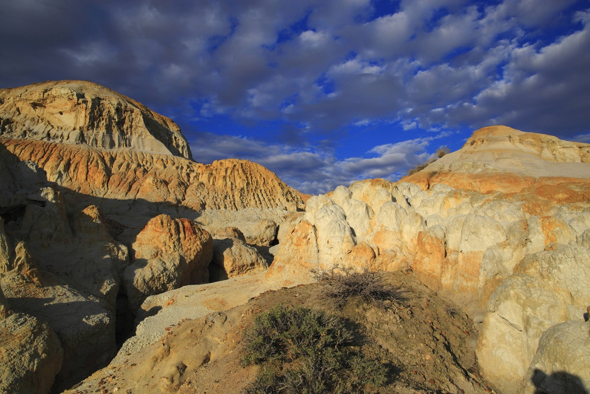 Die imposanten Lehmberge "Flammende Felsen" vor blauem Himmel und malerischen Wolken am Zajsan-See in Kasachstan