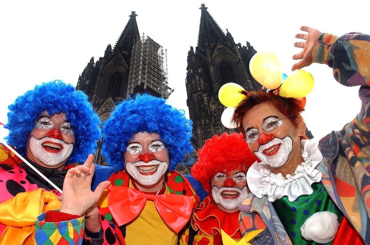 Als Clowns verkleidete Frauen feiern Karneval vor dem Dom in Köln
