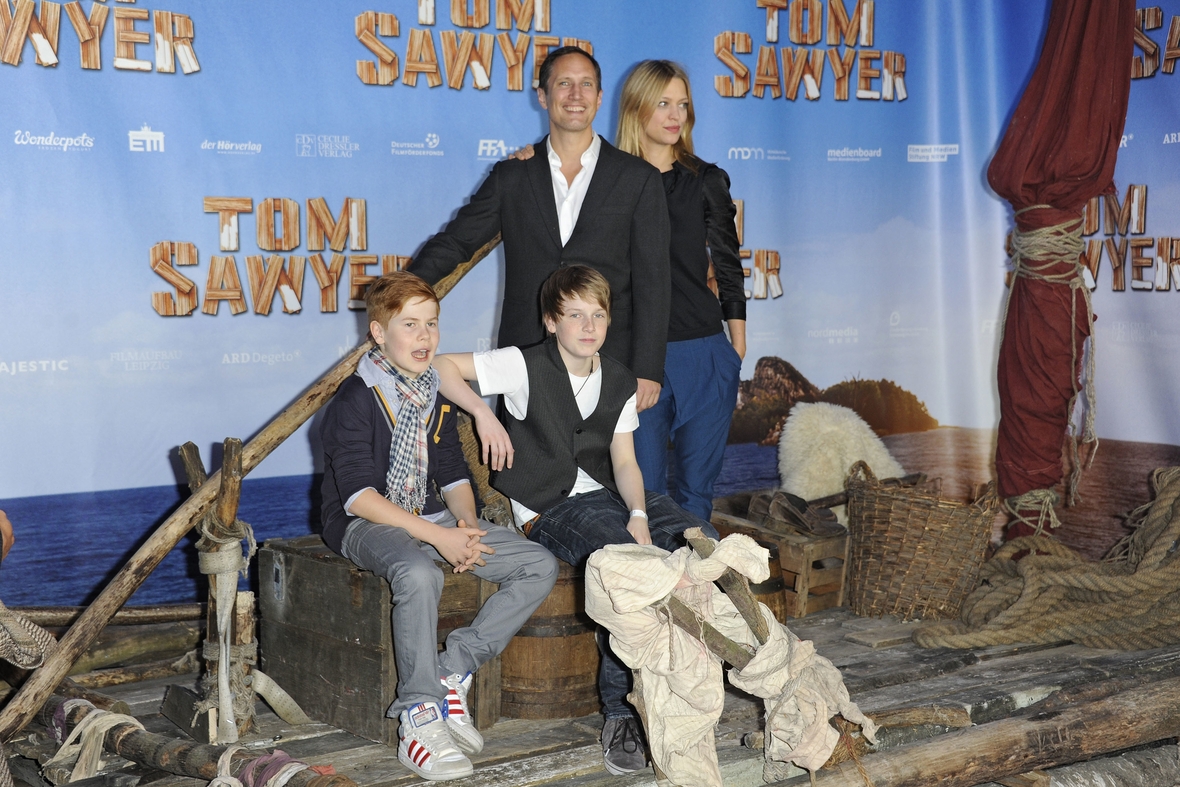 Von links nach rechts: Die Schauspieler Leon Seidel als Huckleberry Finn, Louis Hofmann als Tom Saywer, Benno Fürmann als Joe und Heike Makatsch als Tante Polly bei der Filmpremiere vor dem Filmplakat 