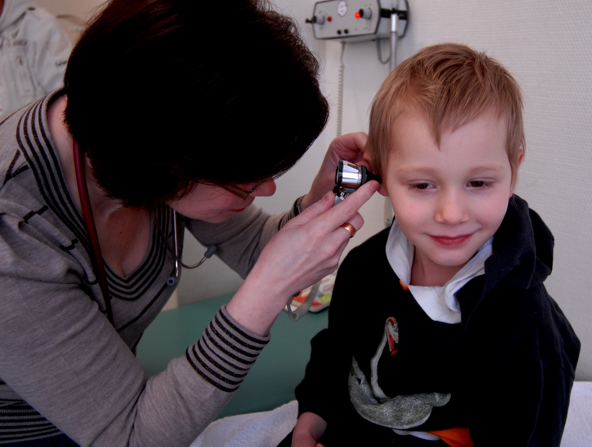 Eine Kinderärztin untersucht einen jungen Patienten.