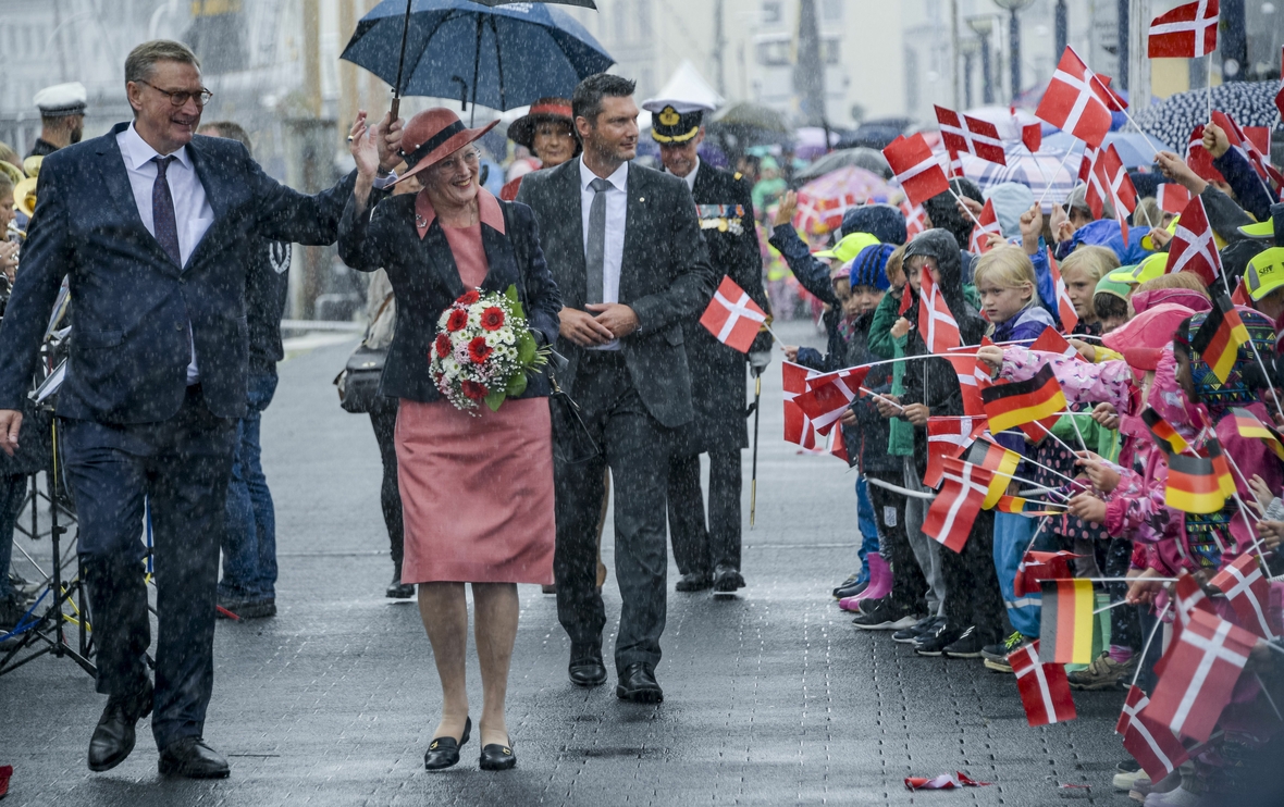 Die dänische Königin Margarethe wird von den Kindern einer dänischen Schule in Schleswig-Holstein mit Fähnchen begrüßt.