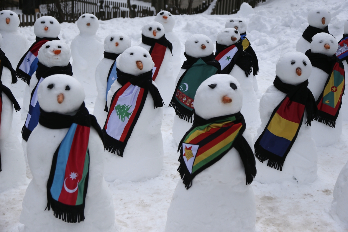 Die Schneemänner tragen Flaggen-Schals. Sie zeigen die Vielzahl der Nationen, die in Davos beim Weltwirtschaftsforum vertreten sind.