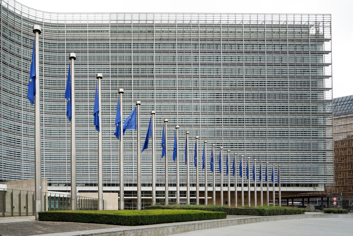 Hauptsitz der Europäischen Kommission in Brüssel. Vor dem großen Gebäude wehen mehr als 20 EU-Flaggen.