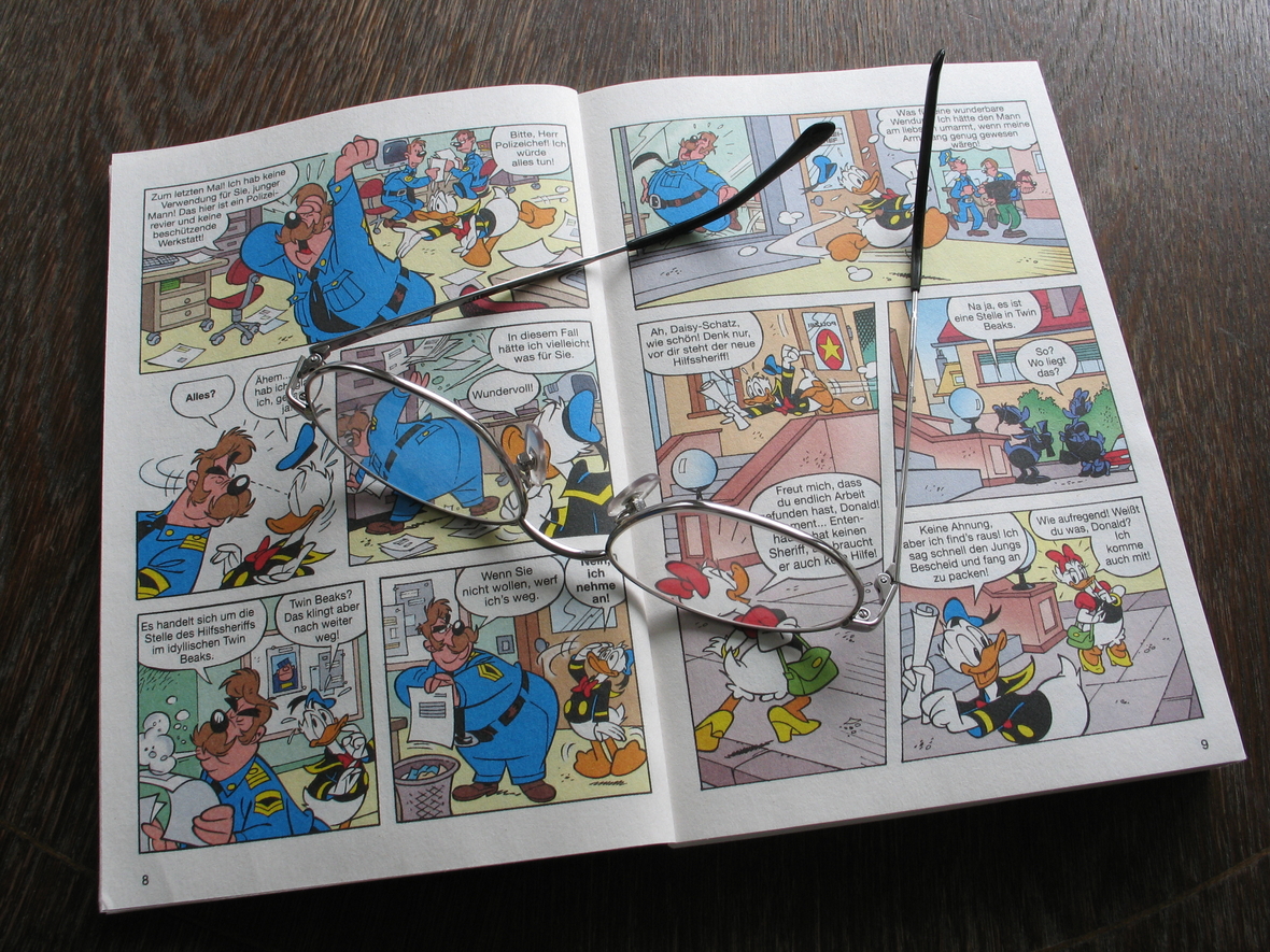 Eine Brille liegt auf einem aufgeschlagenen Comic-Heft mit Donald Duck.