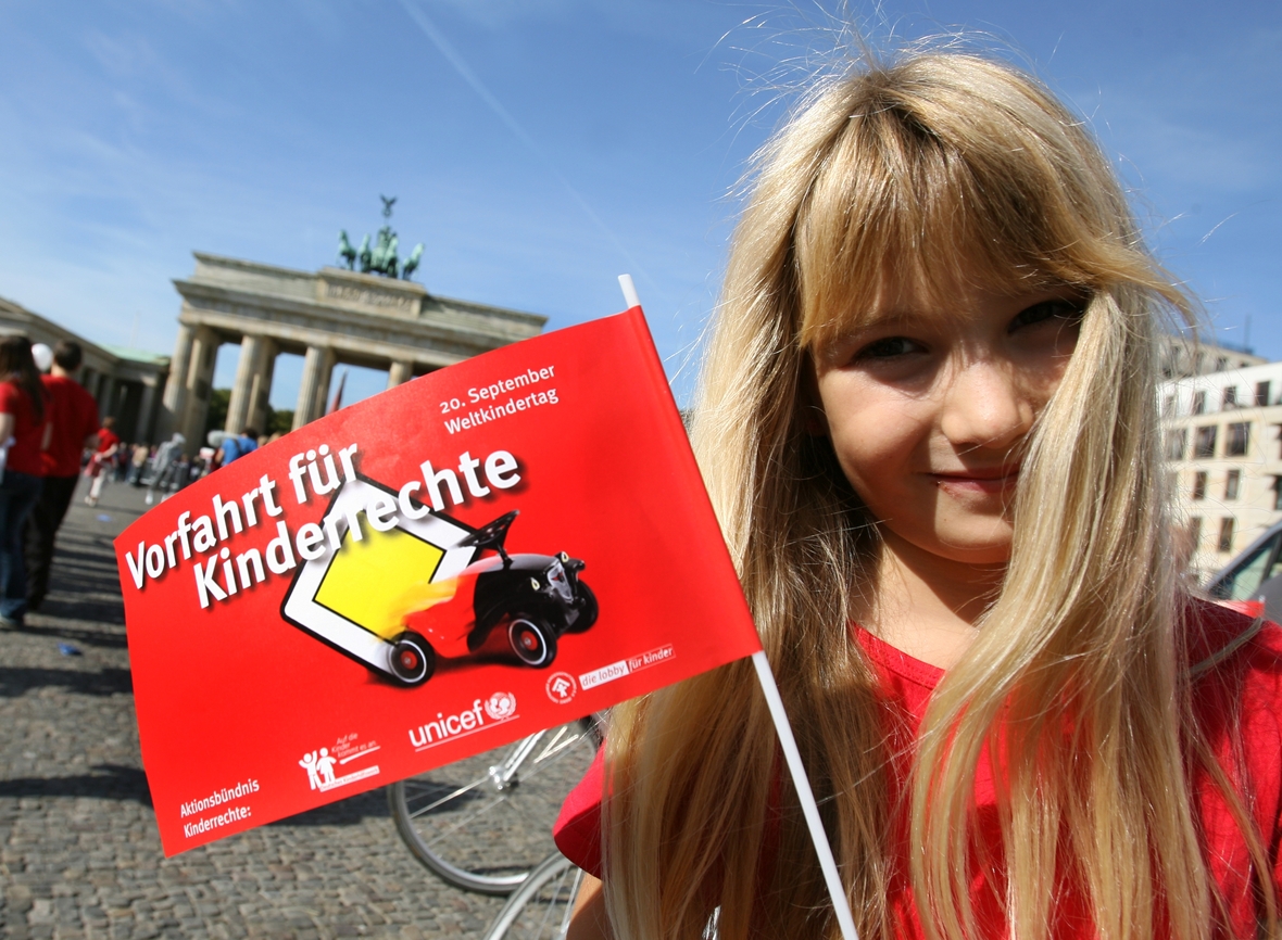 Eine Schülerin hält am 18.09.2009 vor dem Brandenburger Tor in Berlin ein Fähnchen mit der Aufschrift "Vorfahrt für Kinderrechte".  „Vorfahrt für Kinderrechte" fordern der Deutsche Kinderschutzbund, Unicef und das Deutsche Kinderhilfswerk am Weltkindertag.