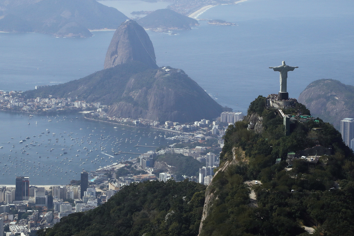 Das Luftbild zeigt im Vordergrund die Christusstatue auf dem Corcovado-Hügel und dahinter den Zuckerhut-Hügel in Rio de Janeiro.