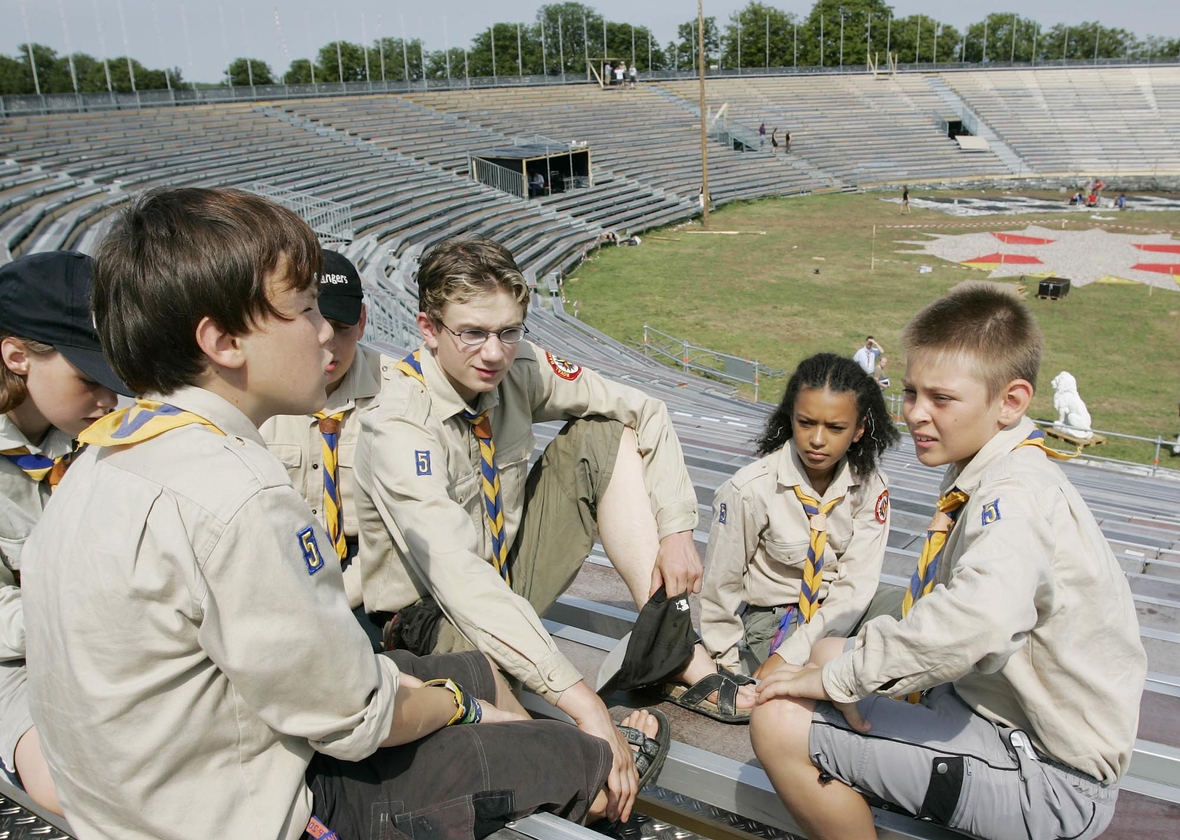 Junge Pfadfinder sitzen bei einem Treffen in Thüringen in einem Stadion. Ihr Motto: Jeden Tag eine gute Tat!