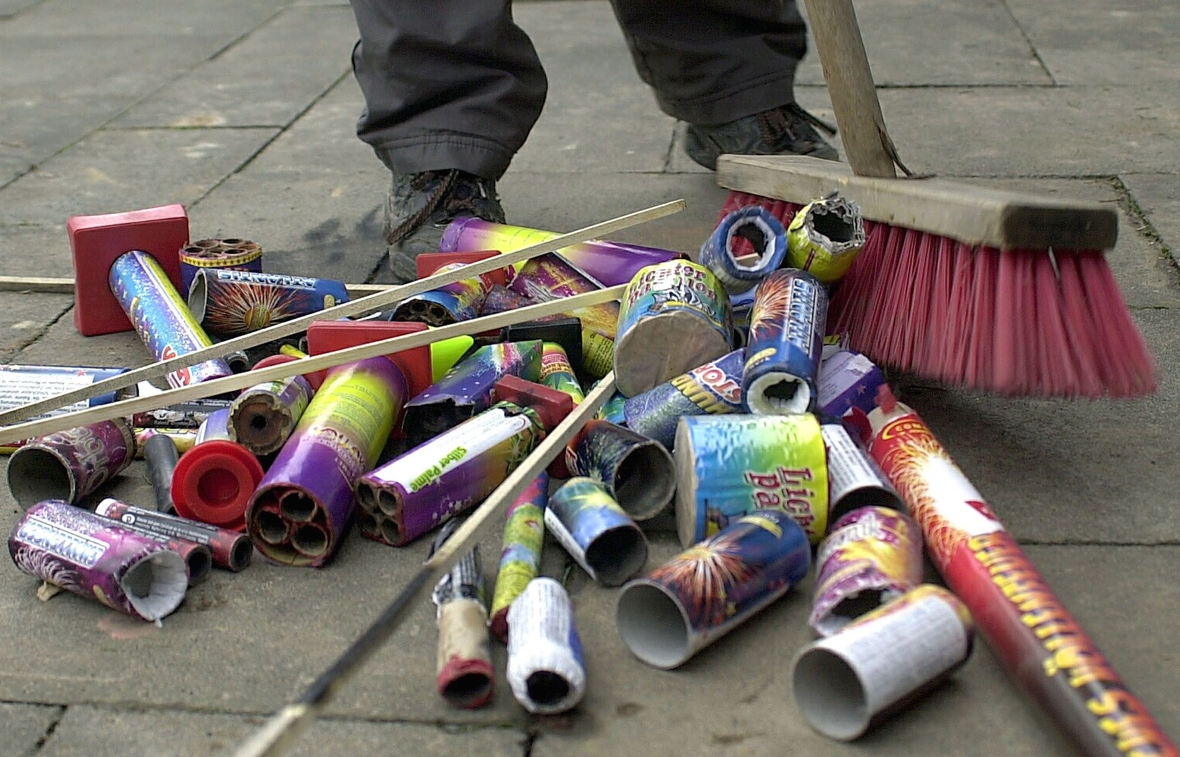 Auf der Straße liegen am Neujahrstag abgebrannte Feuerwerkskörper und werden zusammengefegt.