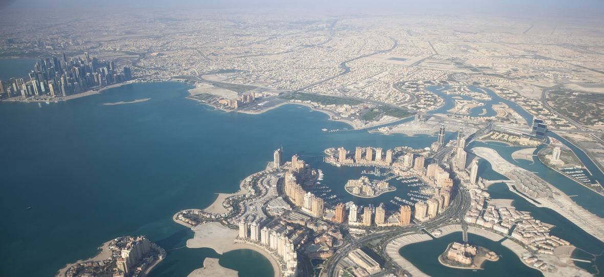 Blick aus dem Fenster eines abfliegenden Flugzeugs auf Katars Hauptstadt Doha und die künstliche Luxus-Insel „The Pearl" ("Die Perle")