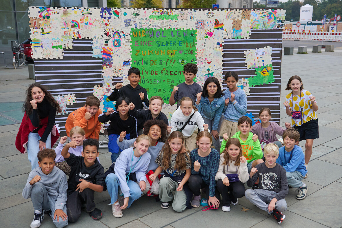 Aktion Weltkindertag 2024: Kinder setzen ein Puzzle zu Kinderrechten zusammen. 