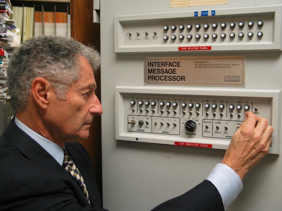 Leonard Kleinrock führt den Computer vor, mit dem die erste Internet-Verbindung zustande kam. Er steht vor dem Computer.