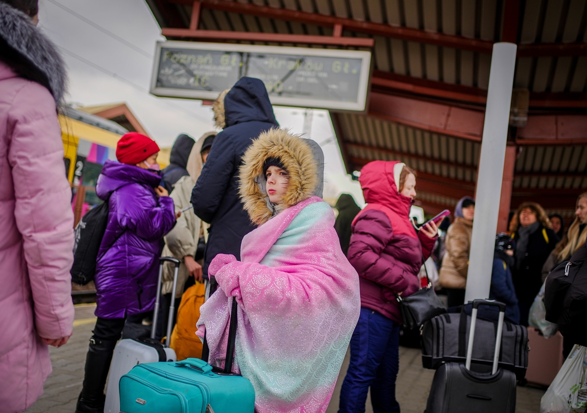 Die Millionen geflüchteter Ukrainer/innen werden zum Beispiel vom Nachbarland Polen aufgenommen. Hier kommen auf dem Bahnhof von Przemysl in der Nähe des ukrainsch-polnischen Grenzübergangs Menschen an. Diese Mutter mit ihrem Kind wartet auf die Weiterfahrt in die polnische Stadt Krakau. 