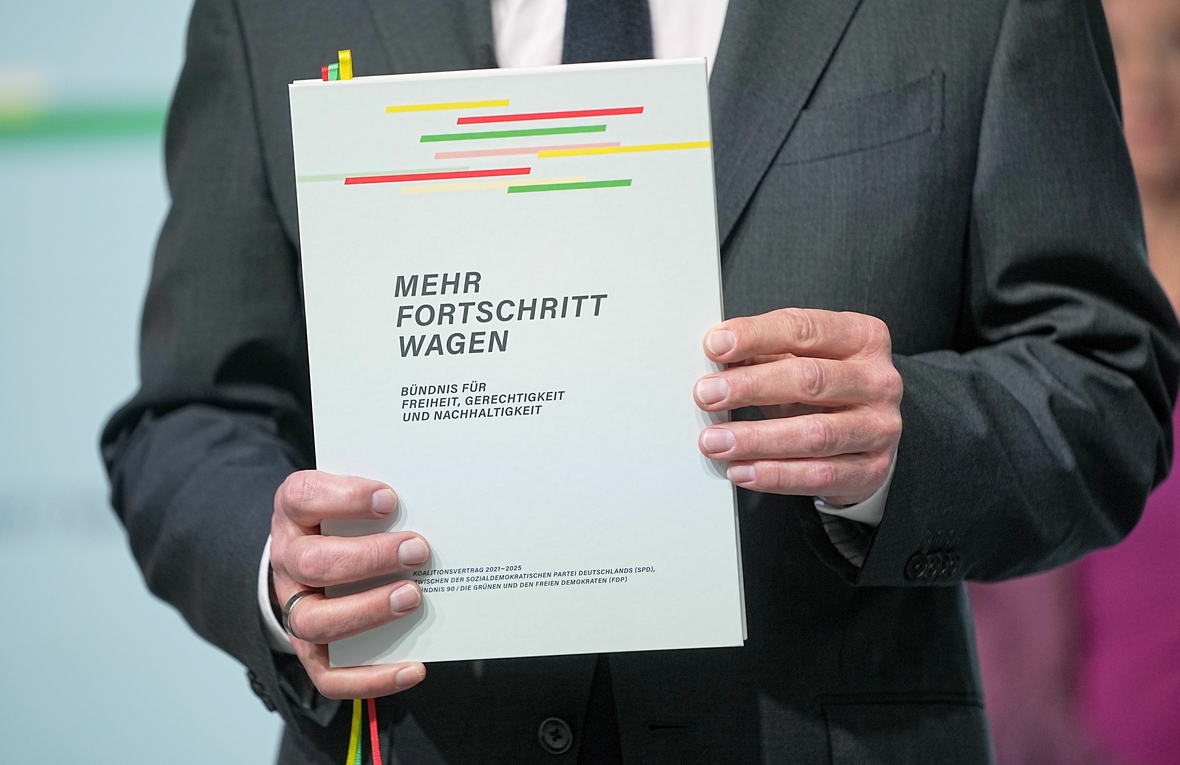 Olaf Scholz hält den Koalitionsvertrag, den SPD, Bündnis 90/Die Grünen und FDP geschlossen haben. Gezeigt wird der Titel des Textes.