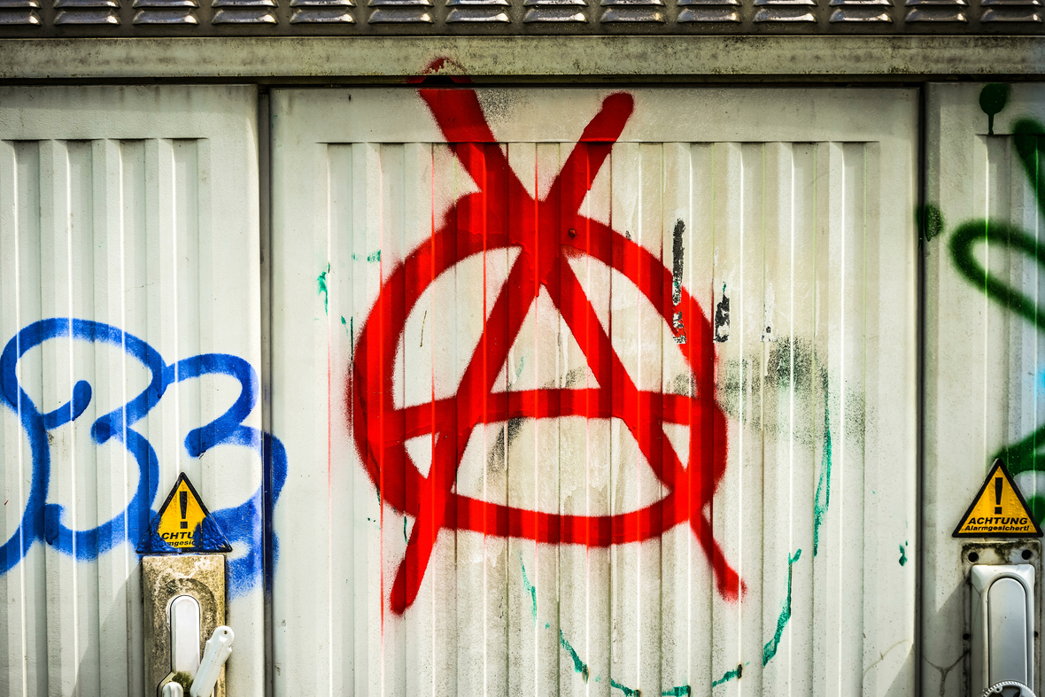 Ein großes "A" in einem Kreis ist auf eine Garagentorwand geschmiert. Das Zeichen steht für "Anarchie".