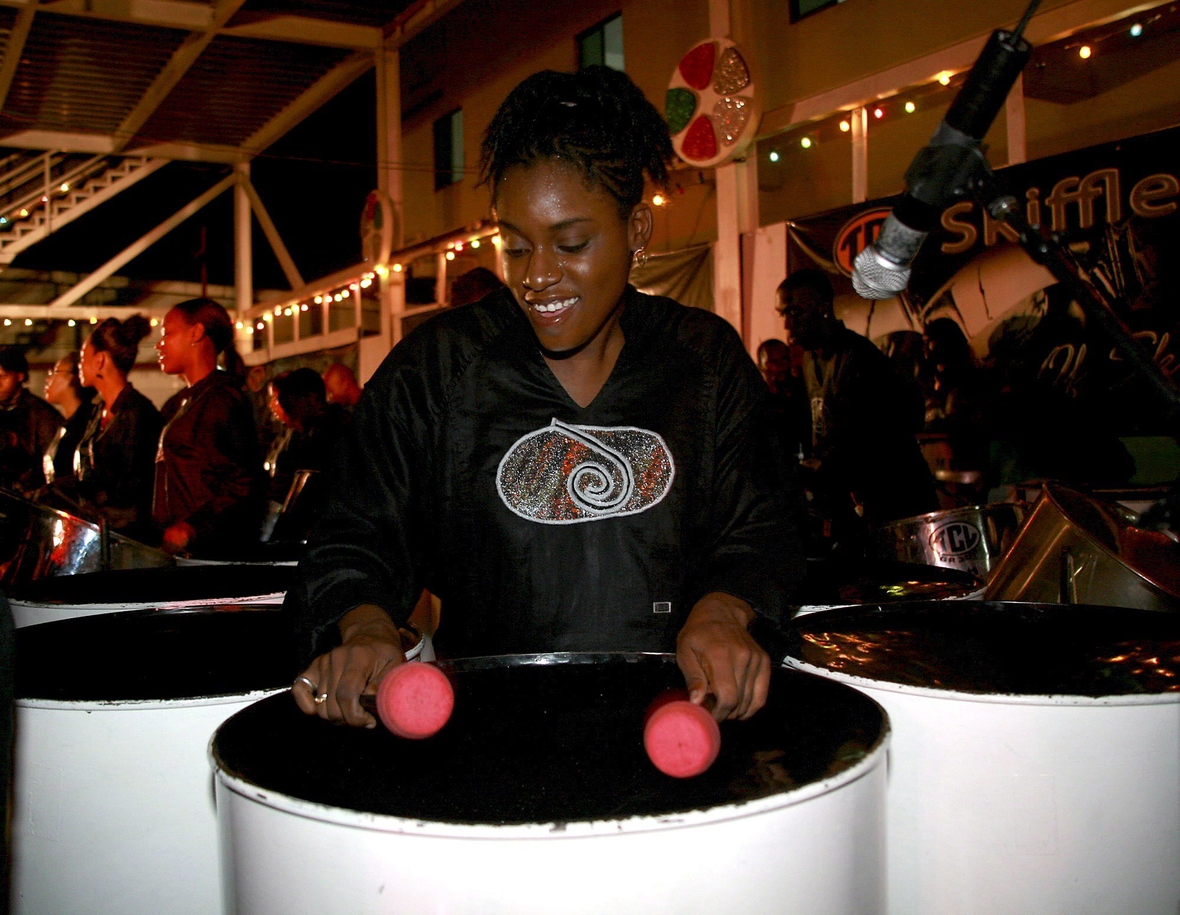 Das Bild zeigt eine Trommlerin mit einer "Steel Pan" in Trinidad und Tobago.