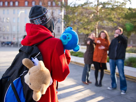 Ein Mädchen, das einen Teddybär hält, wird von ihren Mitschülern gemobbt.