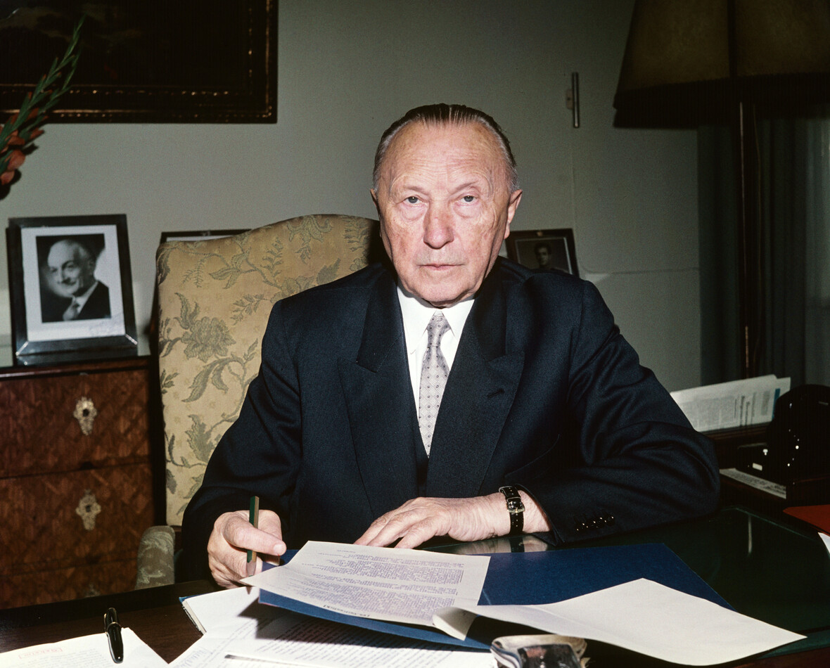 Bundeskanzler Adenauer am Schreibtisch, wo er Akten durchsieht. 