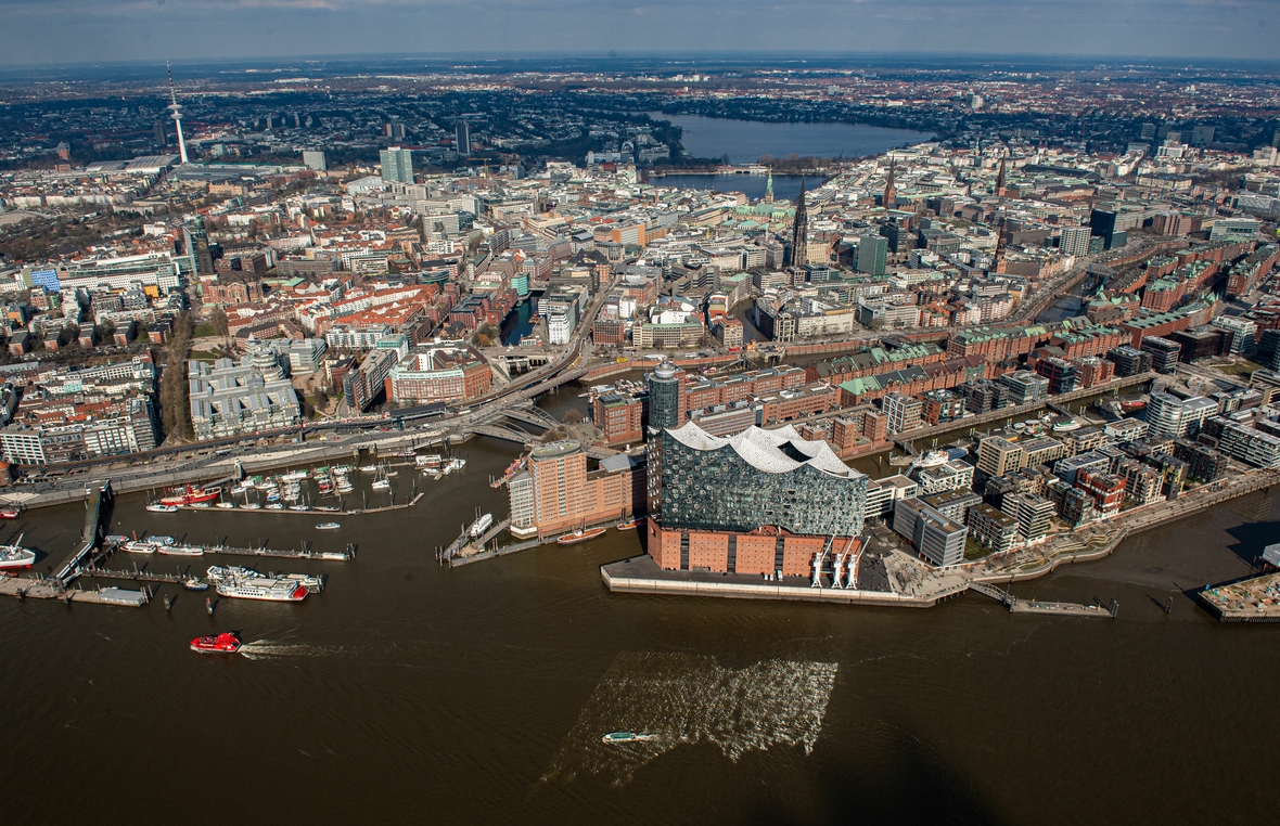 Das Luftbild zeigt die Elbphilharmonie im Hamburger Hafen, die Speicherstadt, das hochmoderne Wohnviertel Hafencity, das Rathaus und im Hintergrund die Alster.