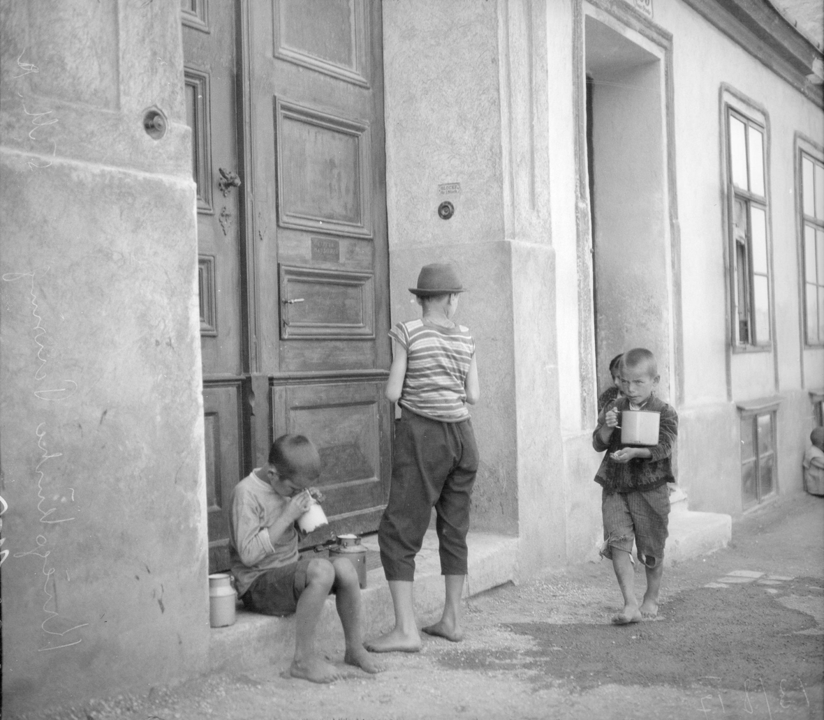 Kinder warten mit Essensschale vor einer Kriegsküche während des Ersten Weltkriegs.