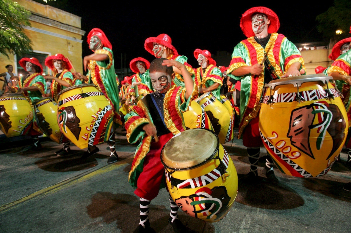 Kinder und Erwachsene in Kostümen trommeln auf einer großen Karnevalsparade in Montevideo, Uruguay.