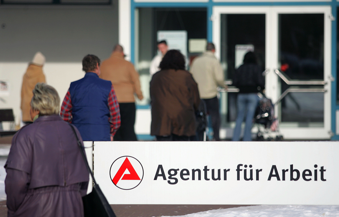 Menschen betreten die Agentur für Arbeit in Potsdam.