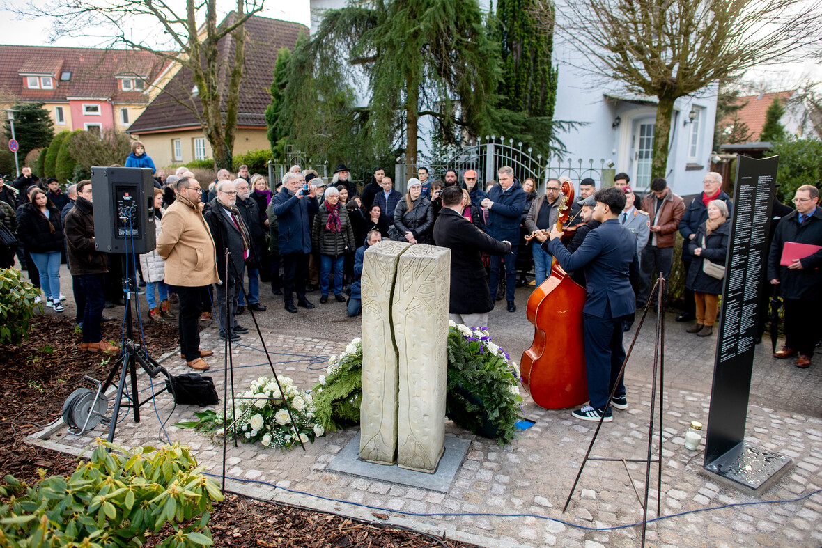 Gedenkfeier in Oldenburg vor einer Gedenkstele mit Namen der im NS verschleppten Sinti und Roma.