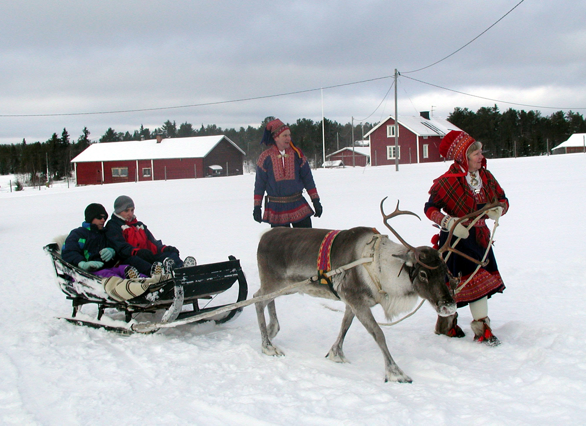 Touristen machen eine Kutschfahrt mit einem Rentier in Muonio, Finnland.