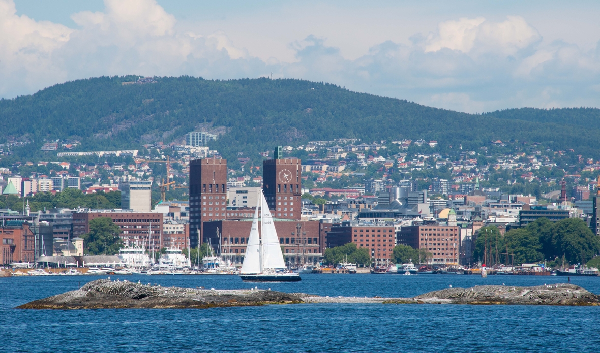 Blick auf Oslo und den Hafen der norwegischen Hauptstadt. Im Hintergrund das monumentale Rathaus mit seinen zwei Türmen.