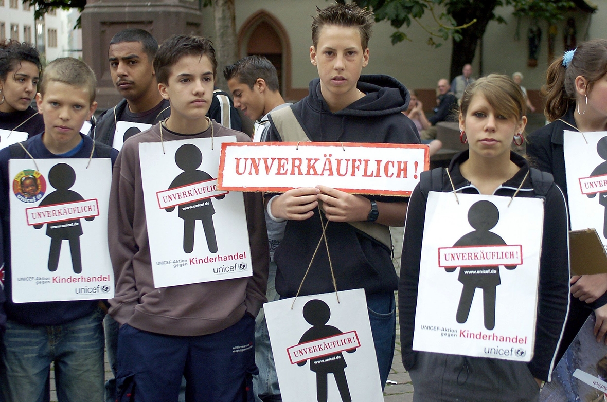 Jugendliche Teilnehmer einer UNICEF-Aktion in Freiburg halten Plakate mit der Aufschrift "Unverkäuflich". Die Aktion fand 2004 statt.