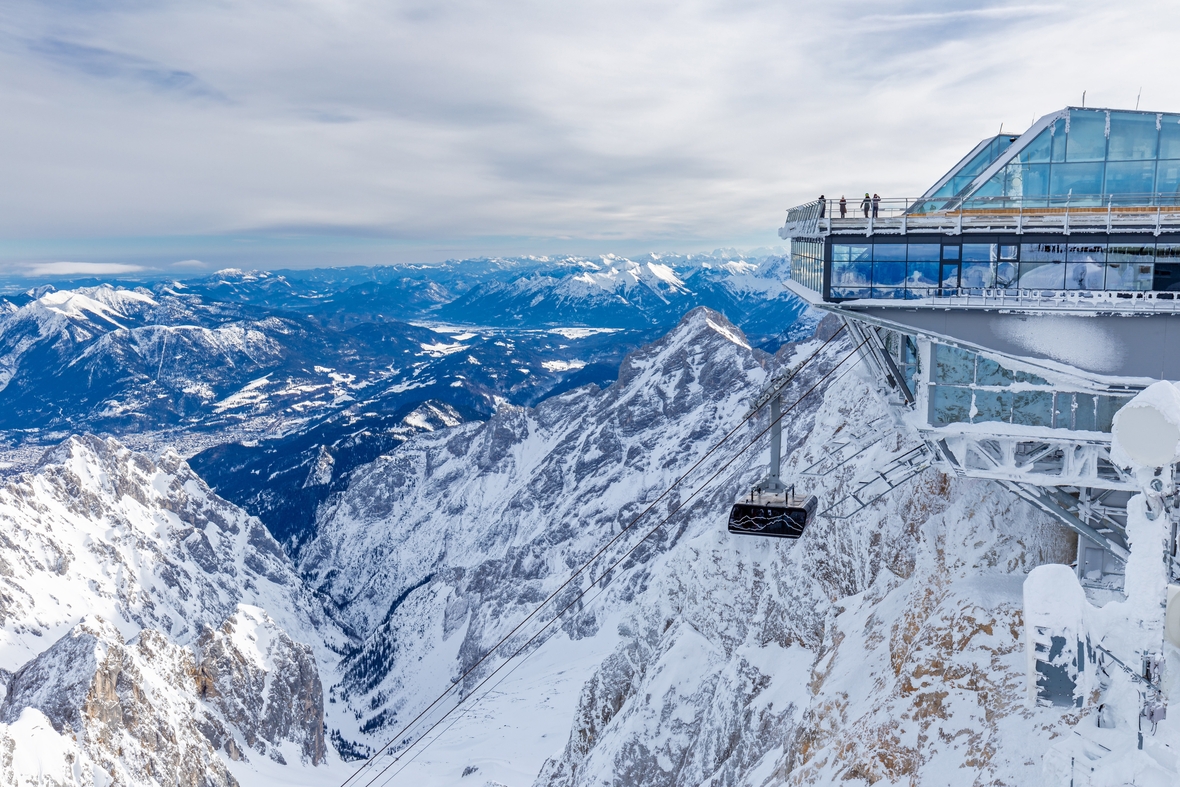 Die Seilbahn erreicht die Gipfelstation auf der Zugspitze. Überall liegt Schnee.
