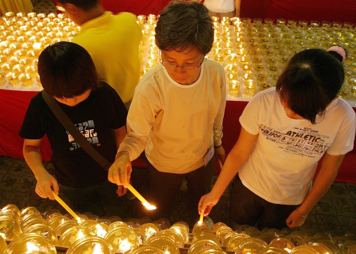 Kuala Lumpur in Malaysia: Buddhistische Kinder und ihre Eltern zünden zu Wesak Öllampen an.