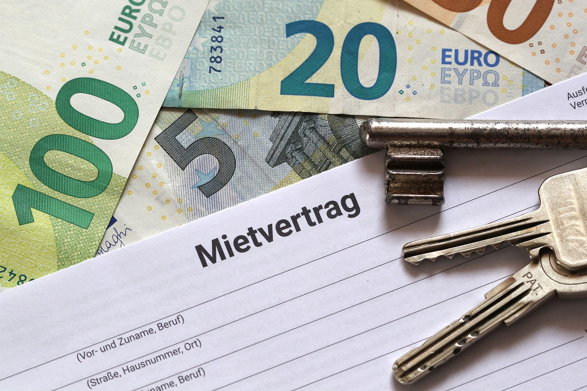 Geld, ein Papier mit "Mietvertrag" aufgedruckt und Schlüssel