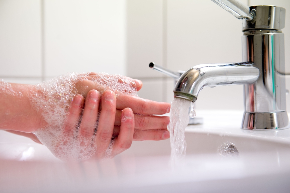 Eine Frau wäscht sich die Hände. Gründliches Händewaschen schützt vor Krankheiten.