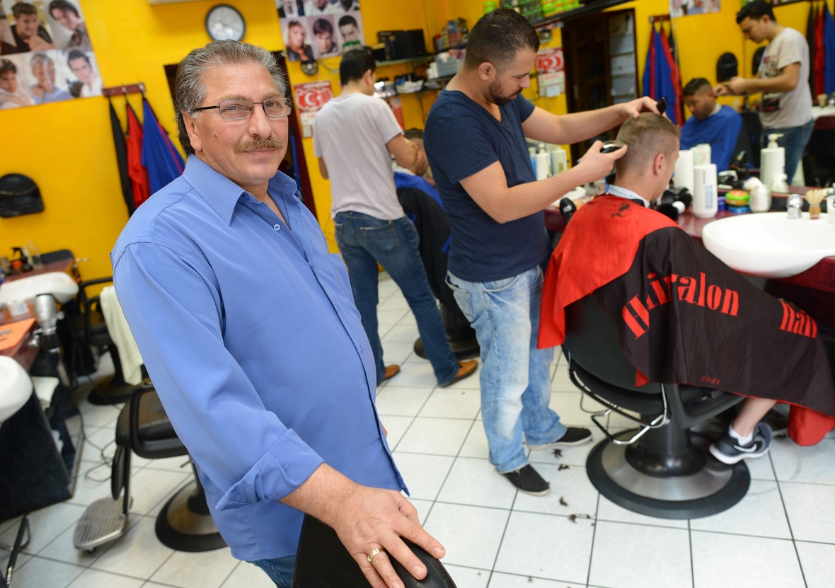 Frisöre in Frankfurt am Main schneiden ihren Kunden die Haare.