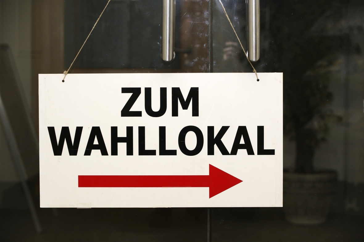 In Bayern und Hessen wird ein neuer Landtag gewählt. Ein Schild zeigt den Weg zum Wahllokal.