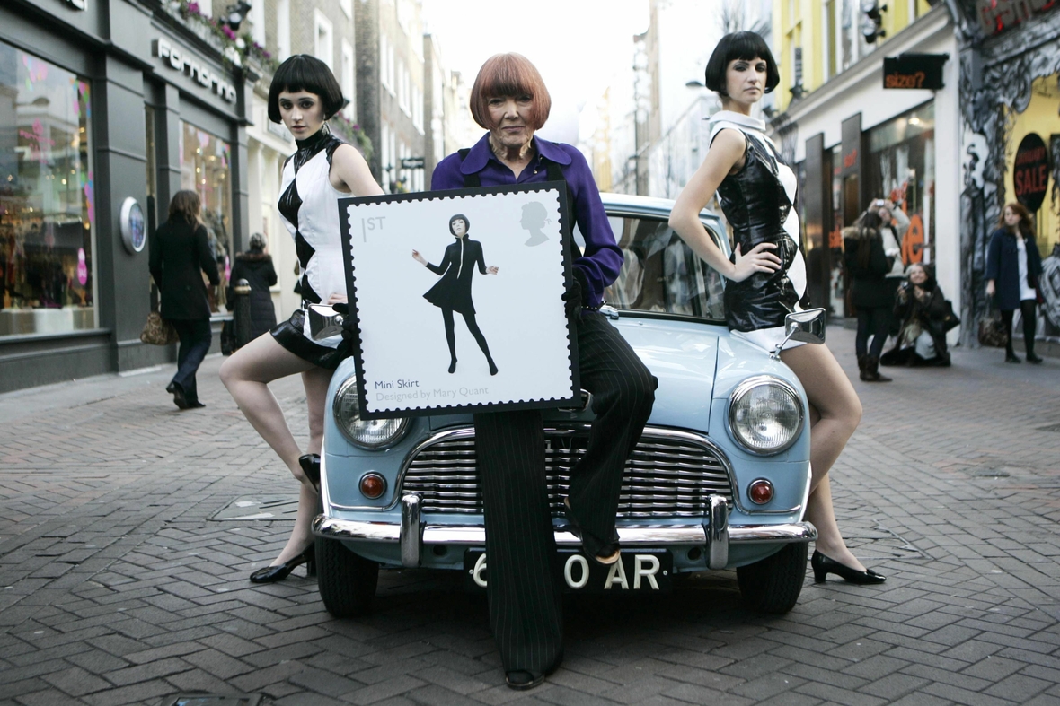 2009: Designerin Mary Quant stellt ihre Briefmarke vor. Auf der Briefmarke ist eine Frau im Minirock abgebildet.