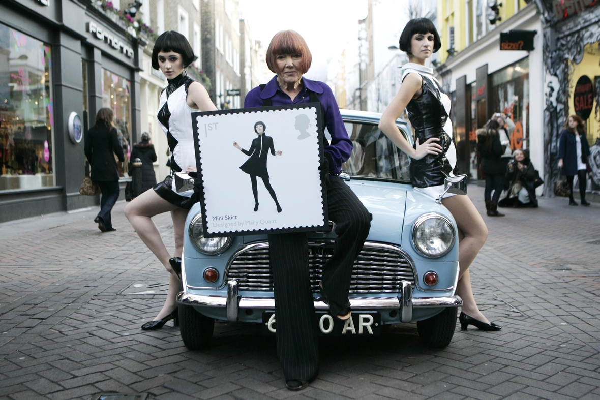 2009: Designerin Mary Quant stellt ihre Briefmarke vor. Auf der Briefmarke ist eine Frau im Minirock abgebildet.