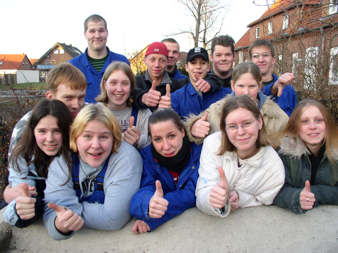 Eine Gruppe von Jugendlichen sitzt vor einem Haus des Christliche Jugenddorfwerk Deutschland. Alle strecken ihren Daumen in die Höhe. Einrichtung des CJD