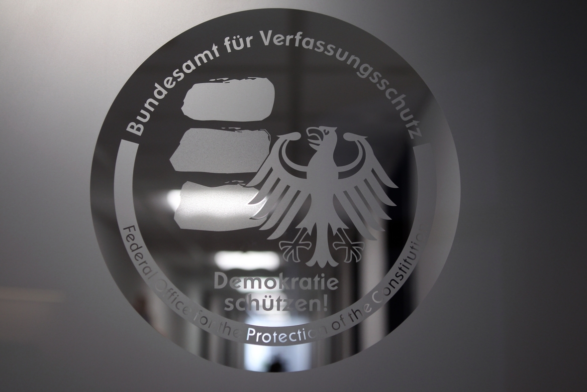 Emblem des Bundesamtes für Verfassungsschutz auf einer Glastür des Gebäudes des BfV.