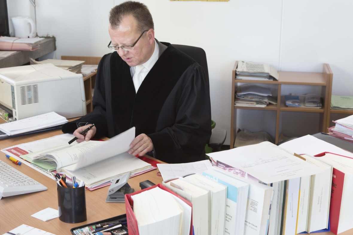 Ein Richter liest Akten, um sich mit dem Sachverhalt eines Verfahrens vertraut zu machen