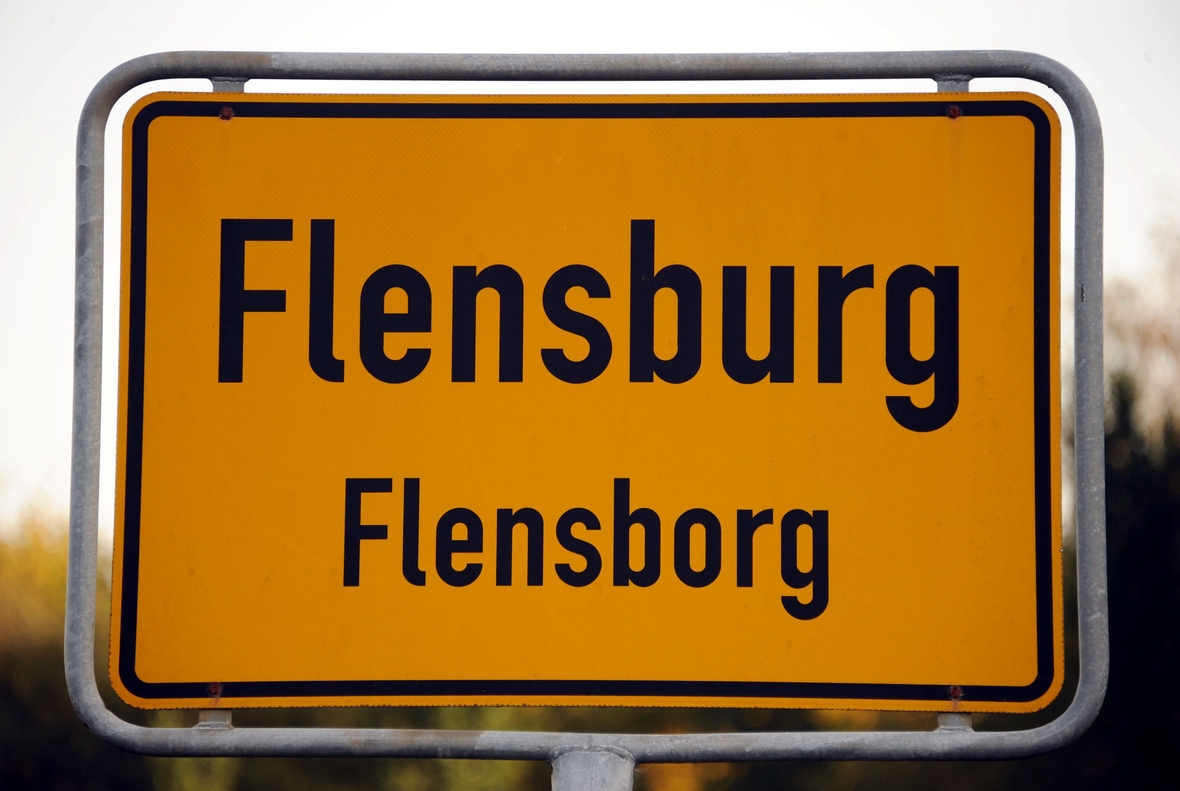 Das Ortsschild von Flensburg in zwei Sprachen: deutsch heißt es "Flensburg" und dänisch: "Flensborg".  Jede/r fünfte Einwohner/in dieser norddeutschen Stadt gehört zur dänischen Minderheit. 