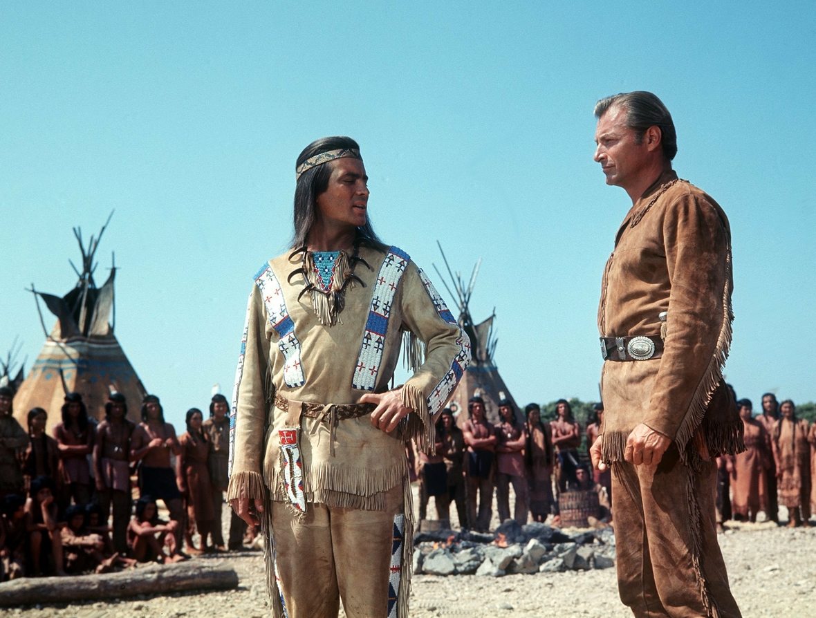 Der Häuptling der Apachen Winnetou (Pierre Brice, links) bespricht sich mit seinem Blutsbruder Old Shatterhand (Lex Barker) in einer Szene der Karl-May-Verfilmung "Winnetou 3" von 1965.