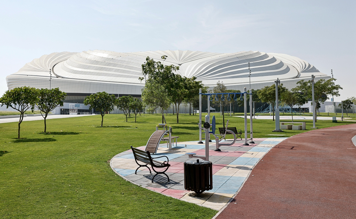 Das al-Janoub-Stadion in al-Wakra hat ein verschließbares Dach. Damit kann der Zuschauerbereich auf 18°C abgekühlt werden. Dafür ist, insbesondere im Sommer bei Außentemperaturen von über 40° Grad, sehr viel Energie notwendig. Das Foto zeigt das Stadion von außen. Um das Stadion herum ist eine Grünanlage angelegt worden. Bäume und Rasen müssen bei der Hitze bewässert werden.
