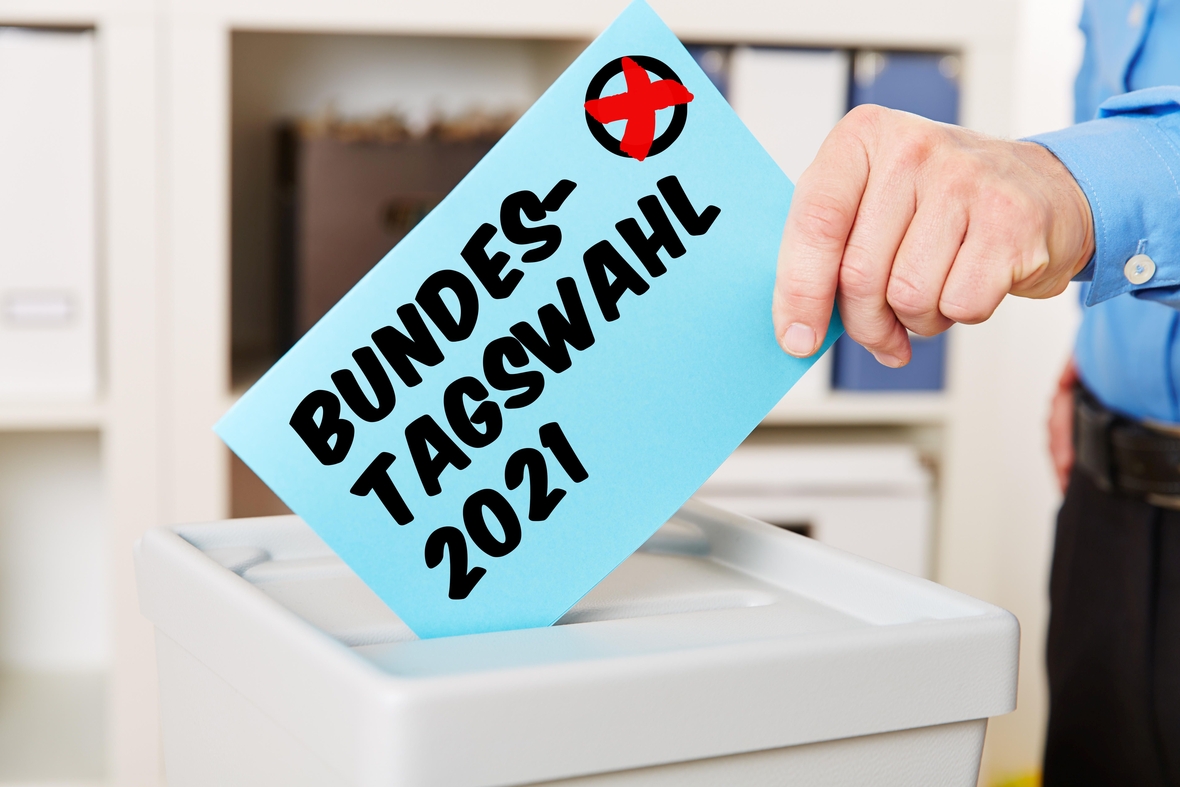 Symbolbild: Hand steckt Stimmzettel in eine Wahlurne bei der Bundestagswahl 2021.
