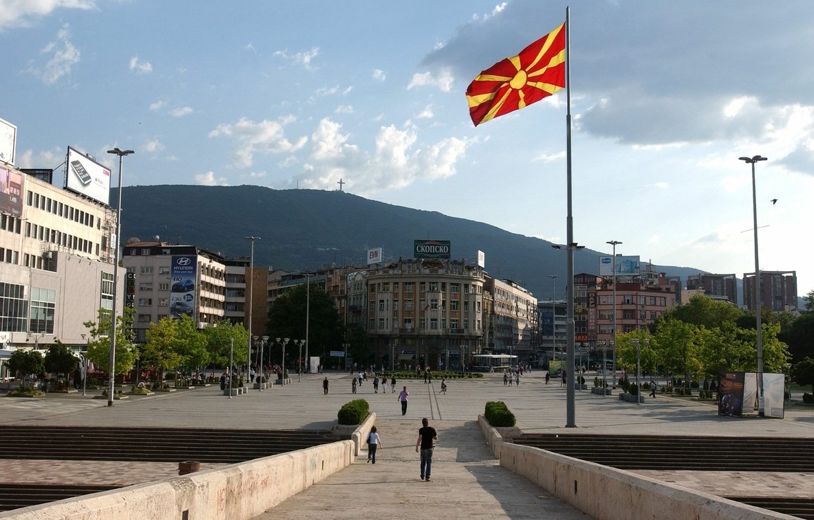 Der Makedonija-Platz im Zentrum von Skopje, der Hauptstadt von Nordmazedonien. Man sieht Menschen auf einem repräsentativen Platz.