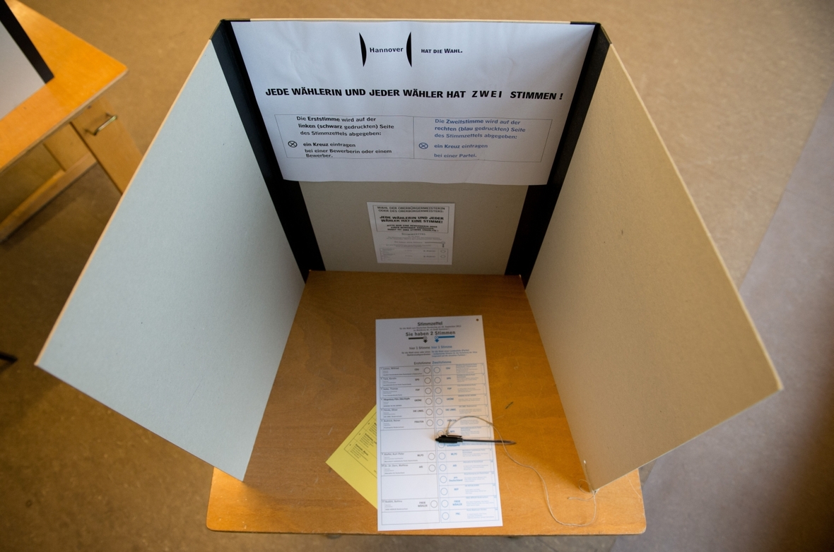 Ein Blick von außen in eine Wahlkabine. Immer vorhanden ist ein Stift und eine Erklärung, wie die Stimmabgabe verläuft.